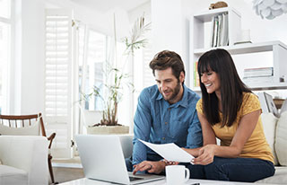 Couple on couch looking at laptop